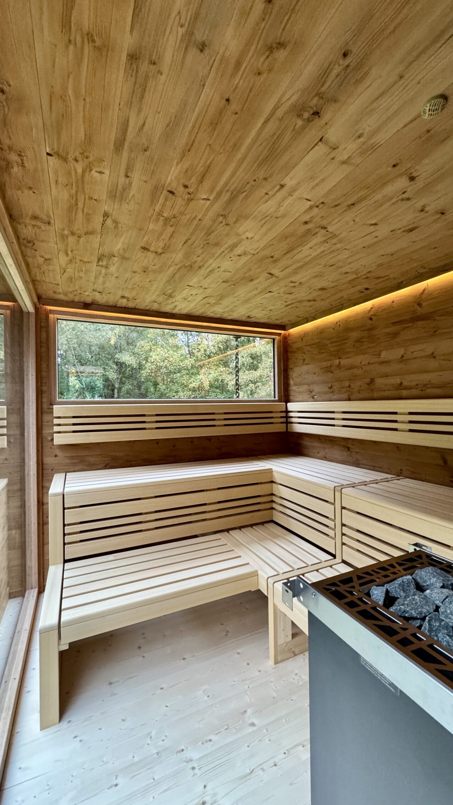 Moderne Gartensauna mit Spionspiegelglas und großer Glasfront von PLUSGRAD° Saunakonzept